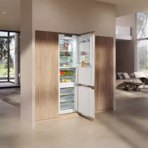 Miele Einbaukühlschrank mit Gefrierfach in Holzfront, geöffnete Tür zeigt Lebensmittel, modern integriert für frische und übersichtliche Lagerung